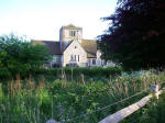 The beautiful 800 year old St. Margaret's Church in Chipstead, Surrey; evening rays warm flintwork walling and stone trimmings�quoins, window mullions, tracery, window surrounds, plinths, and parapets.